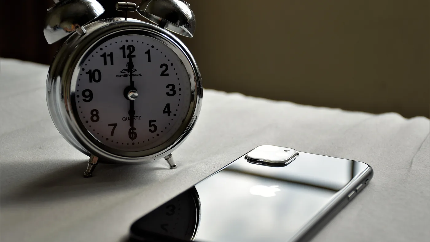 A separate alarm clock is the cheapest effective option, and the one nobody wants to hear.